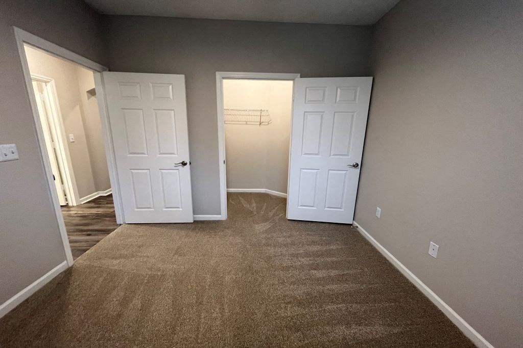 a empty room with two doors and a carpeted floor at Carlton Park Apartment Homes, Flowood, MS