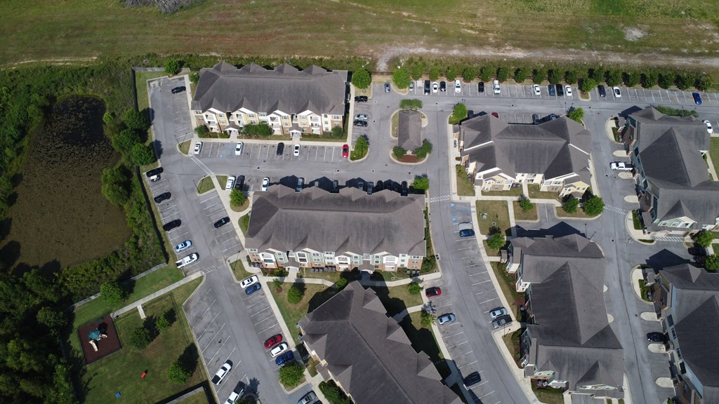 an aerial view of a parking lot with houses and cars at Audubon Park Apartment Homes, Louisiana, 70791