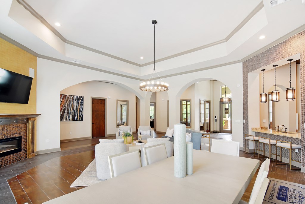 a large living room with a white table and chairs and a fireplace at Audubon Park Apartment Homes, Louisiana, 70791