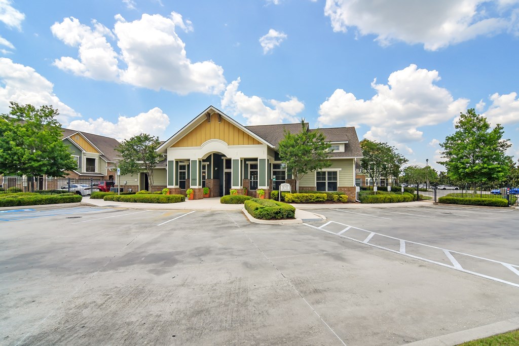an empty parking lot in front of a building with trees at Audubon Park Apartment Homes, LA