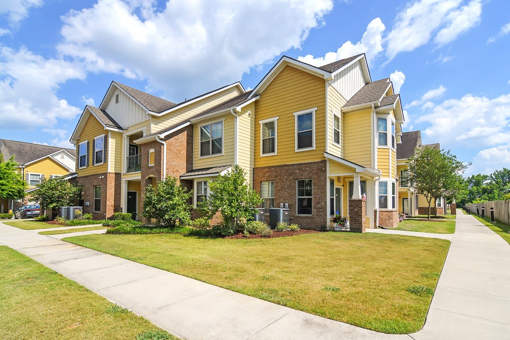 a row of yellow and brick homes on the side of a sidewalk at Audubon Park Apartment Homes, LA