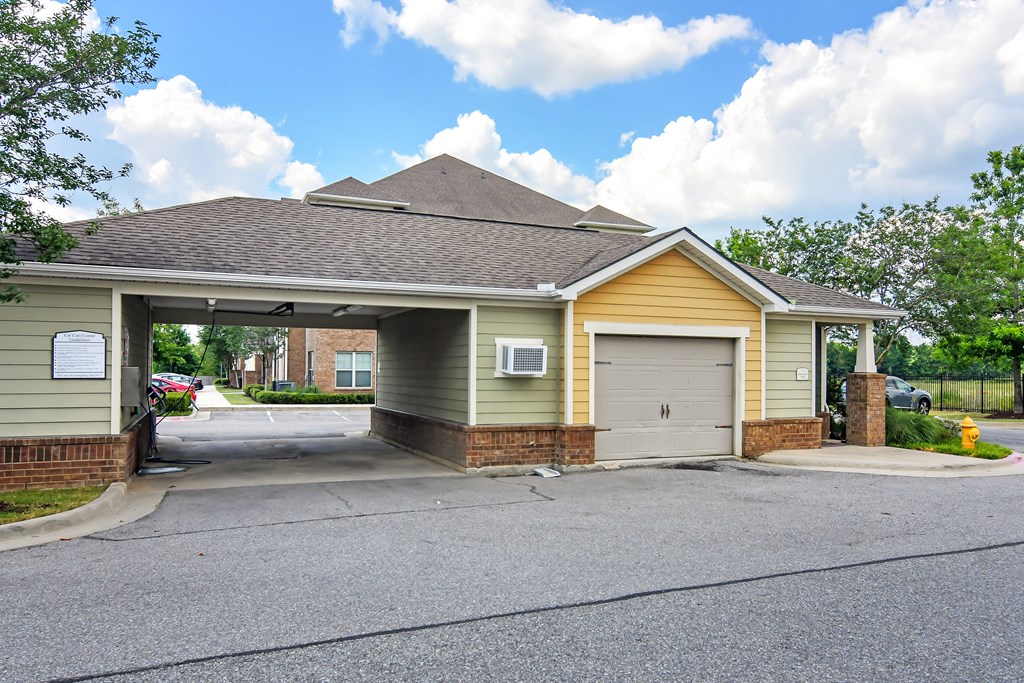the front of a yellow house with a garage at Audubon Park Apartment Homes, Louisiana