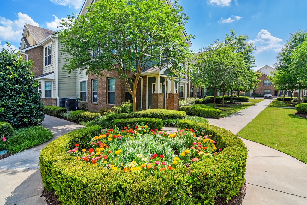 a flower garden in the middle of a sidewalk in front of some houses at Audubon Park Apartment Homes, Louisiana, 70791