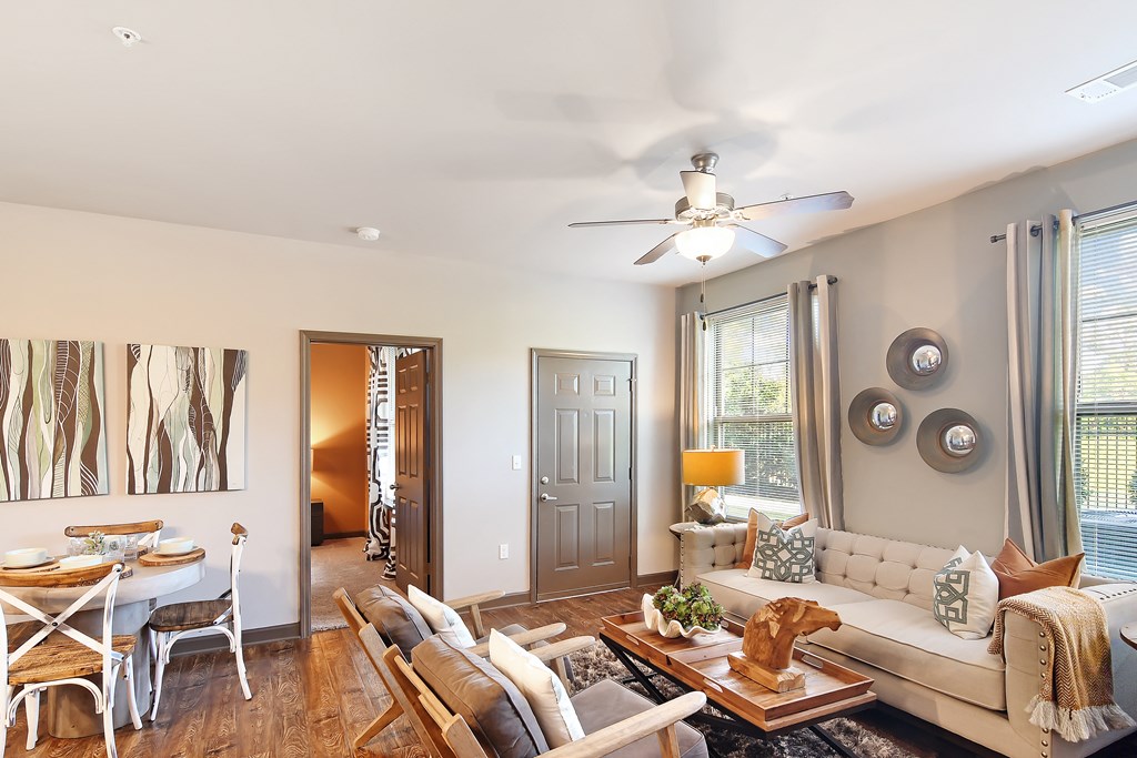 a living room with a couch and a table and a ceiling fan at Audubon Park Apartment Homes, Louisiana