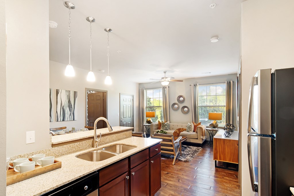 a kitchen and living room with a refrigerator and a sink at Audubon Park Apartment Homes, Louisiana