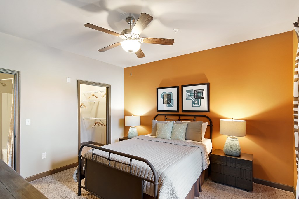 a bedroom with a large bed and a ceiling fan at Audubon Park Apartment Homes, Zachary, 70791
