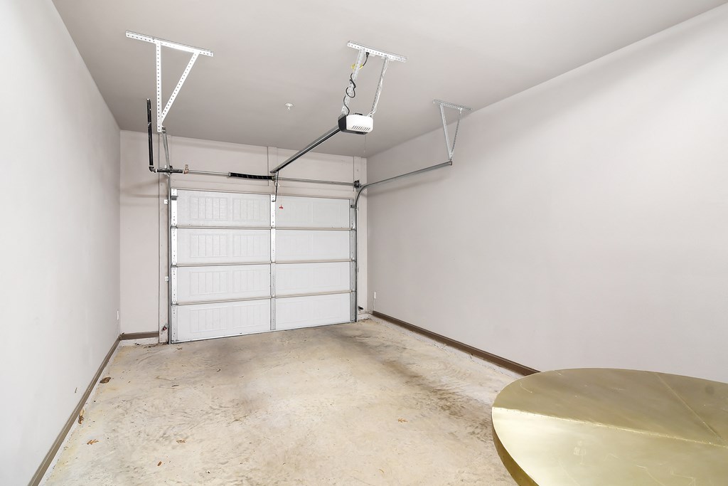 a white room with a table and a garage door at Audubon Park Apartment Homes, Louisiana, 70791
