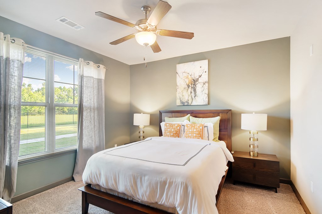 a bedroom with a large bed and a ceiling fan at Audubon Park Apartment Homes, Louisiana, 70791