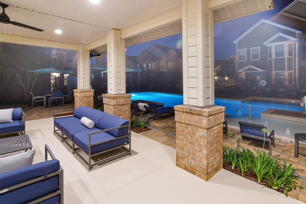 the pool area at the preserve at ballantyne commons with couches and chairs at Audubon Park Apartment Homes, Louisiana