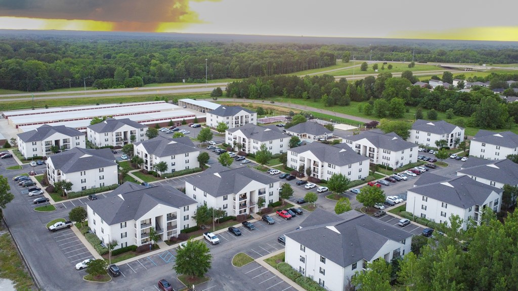 an aerial view of a neighborhood of houses with cars parked in a parking lot at Avalon Apartment Homes, Starkville, 39759