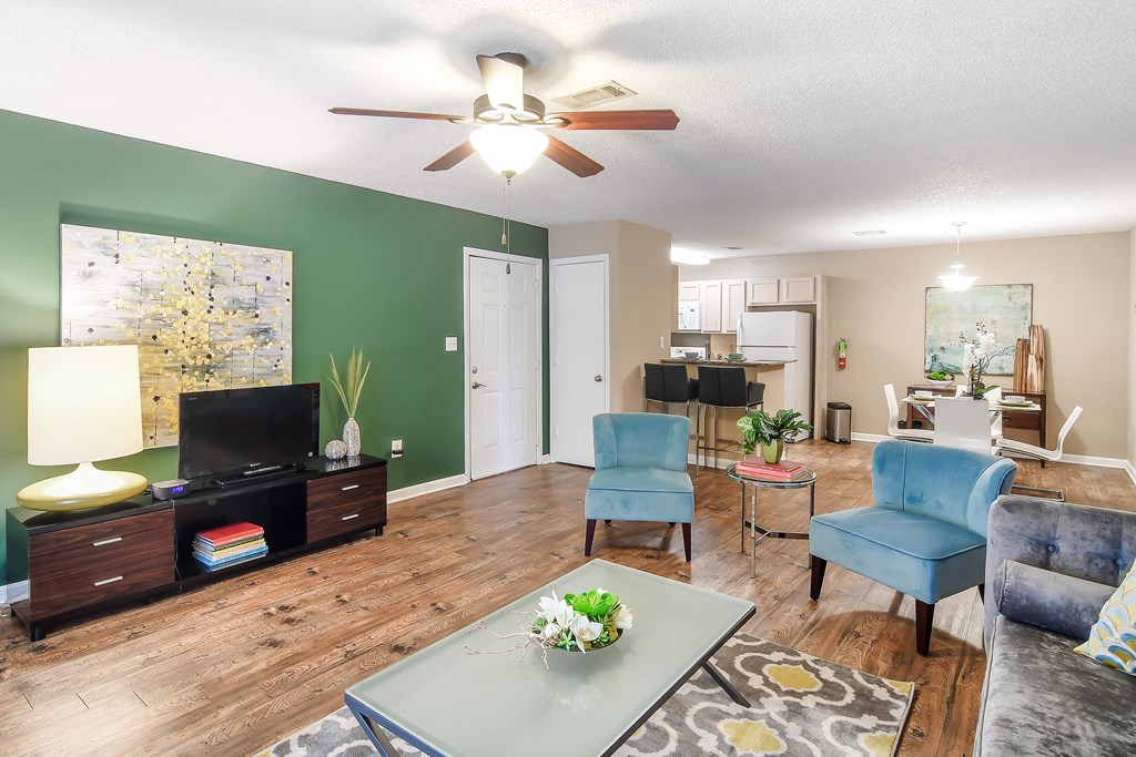 a living room with green walls and a ceiling fan at Avalon Apartment Homes, Starkville, MS, 39759