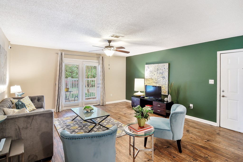 a living room with green walls and a ceiling fan at Avalon Apartment Homes, Starkville, MS, 39759