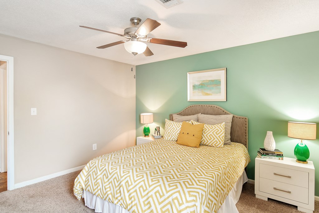 a bedroom with a large bed and a ceiling fan at Avalon Apartment Homes, Starkville
