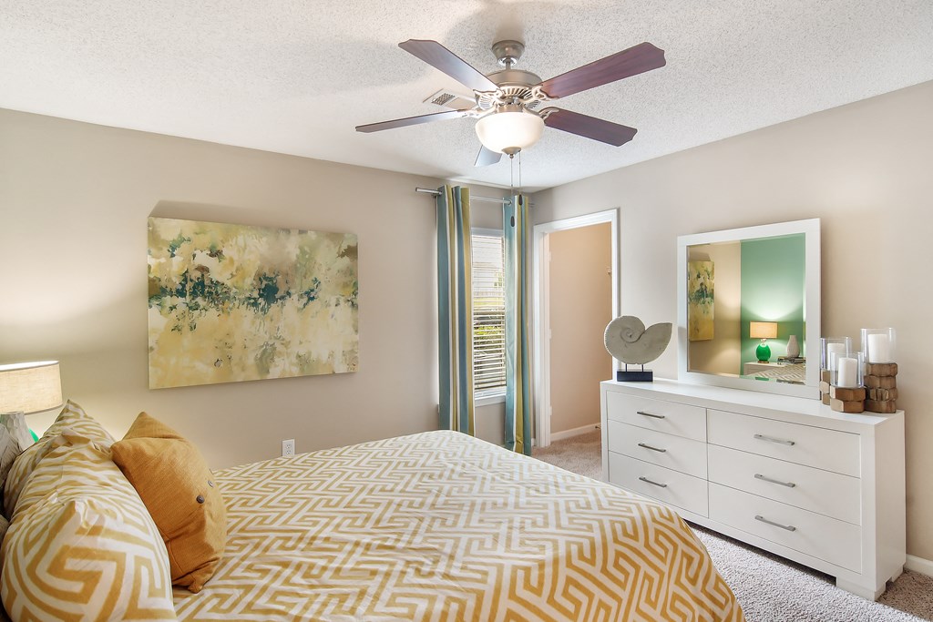a bedroom with a ceiling fan and a bed at Avalon Apartment Homes, Starkville, 39759