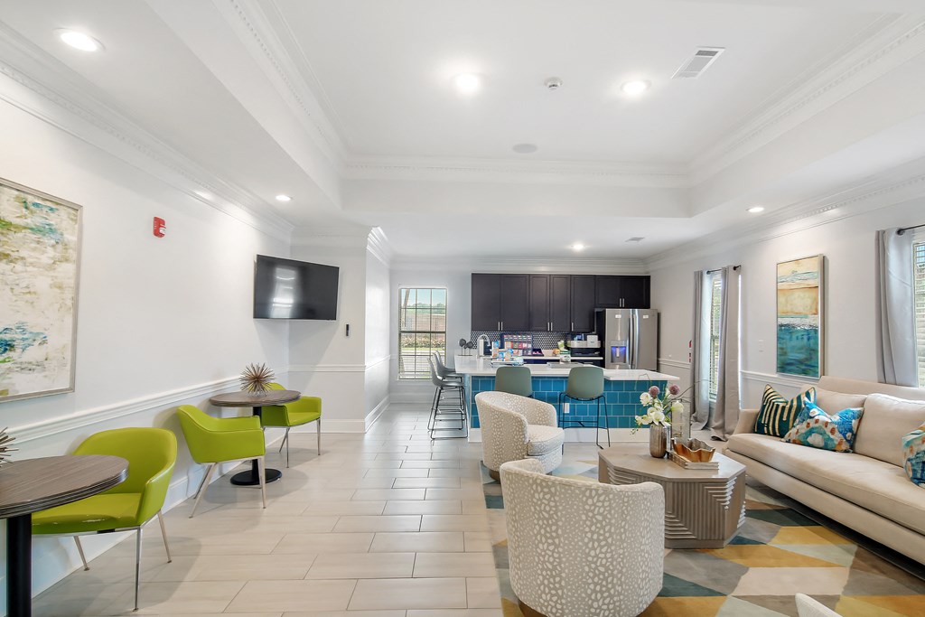 a living room with a couch and chairs and a kitchen with a table and chairs at Avalon Apartment Homes, Starkville
