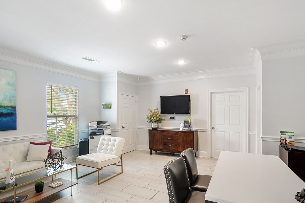 a living room with a white table and chairs and a television at Avalon Apartment Homes, Starkville, MS, 39759