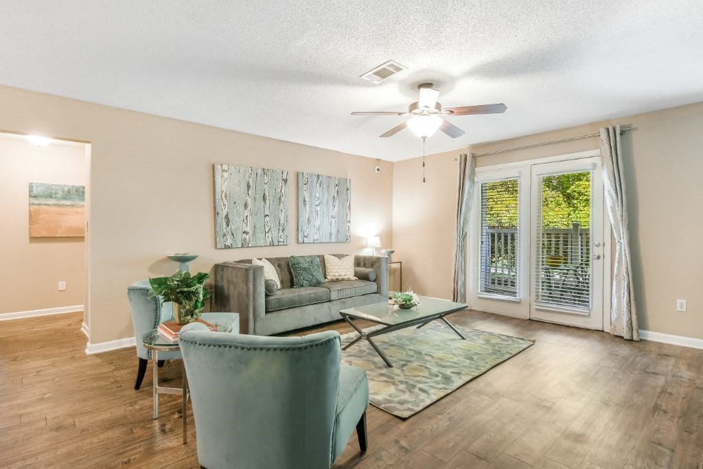 a living room with furniture and a ceiling fan at Avalon Apartment Homes, Starkville, 39759