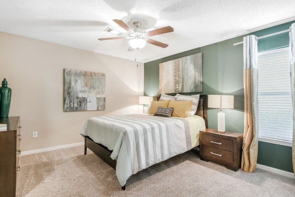 a bedroom with a bed and a ceiling fan at Avalon Apartment Homes, Starkville, Mississippi, 39759