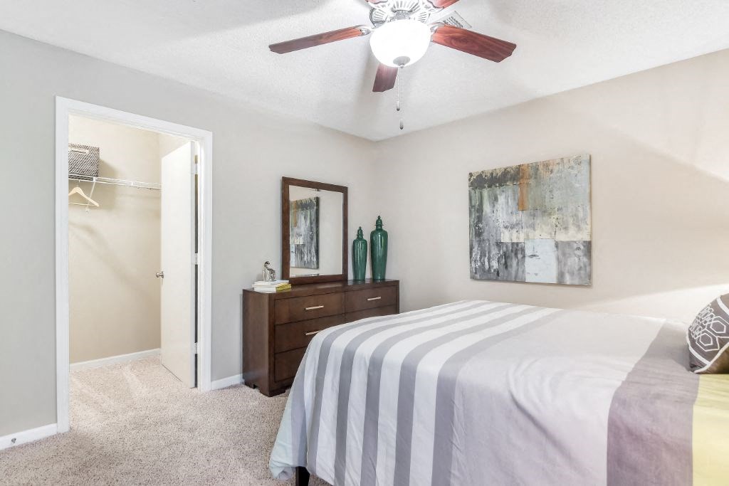a bedroom with a bed and a ceiling fan at Avalon Apartment Homes, Starkville, MS