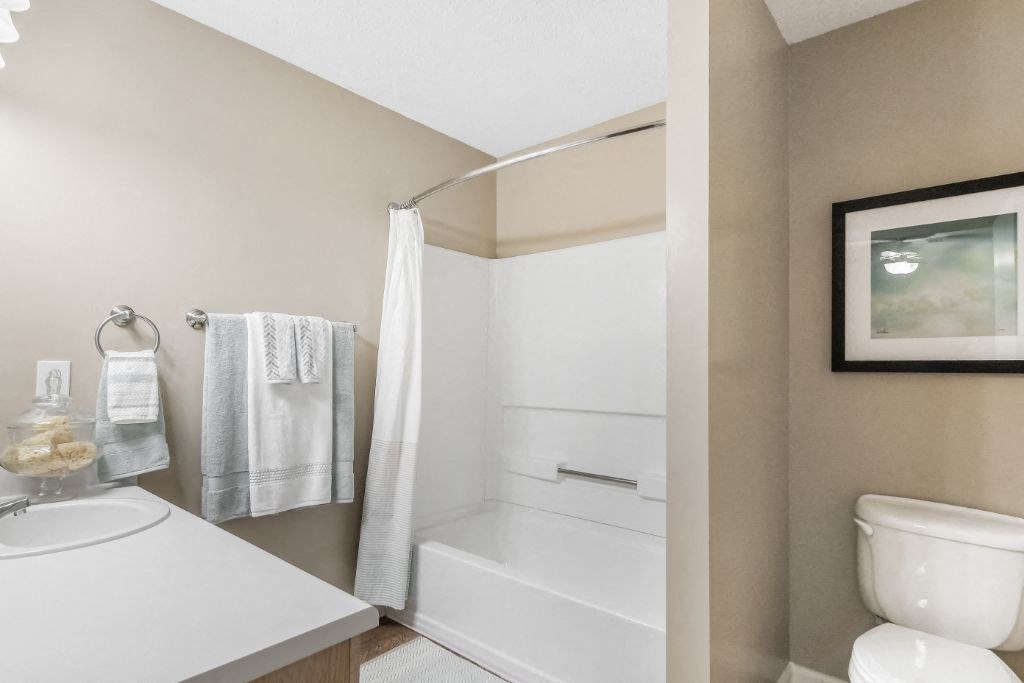 a bathroom with a toilet and a sink and a towel rack at Avalon Apartment Homes, Mississippi
