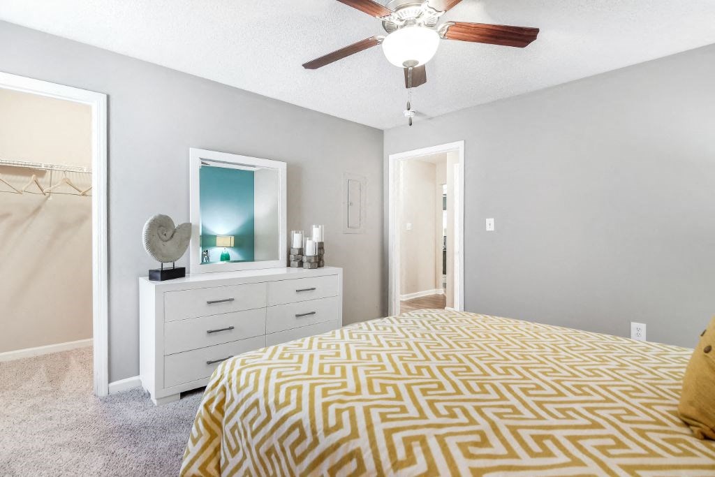 a bedroom with a bed and a ceiling fan at Avalon Apartment Homes, Starkville, MS, 39759