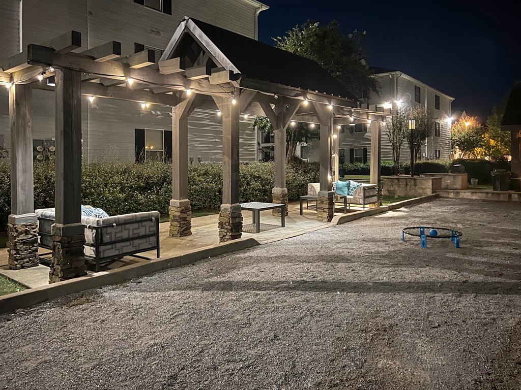 a patio with benches and lights on a house at night at Avalon Apartment Homes, Starkville, MS, 39759