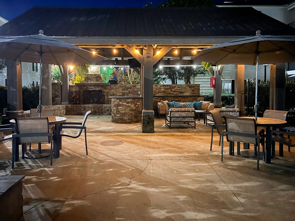 the patio of a restaurant with tables and umbrellas at Avalon Apartment Homes, Starkville, MS, 39759