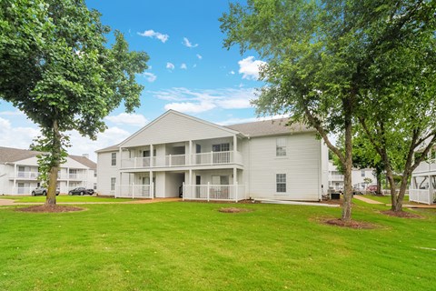 the outlook of a white apartment building with trees