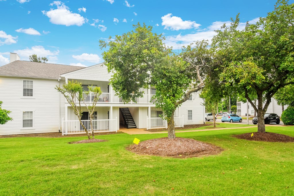 the outlook of a white condominium building with trees