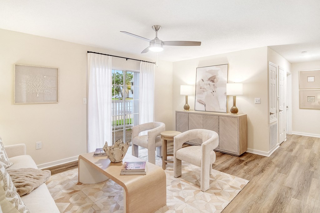 a living room with a table and chairs and a ceiling fan at The Oliver Apartment Homes, Mississippi