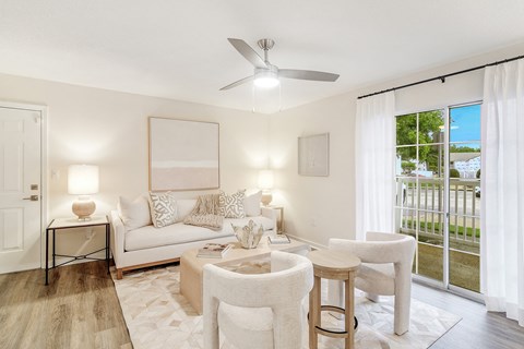 a living room with white furniture and a ceiling fan at The Oliver Apartment Homes, Olive Branch, MS