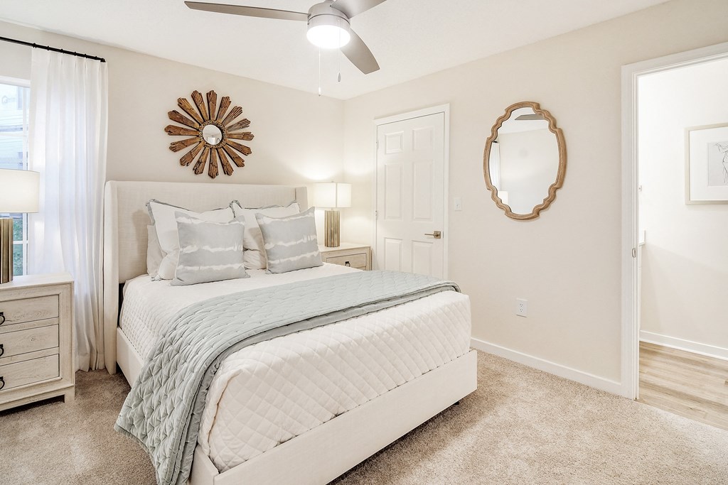 a bedroom with a white bed and a mirror at The Plantation Apartment Homes, Mississippi, 38654