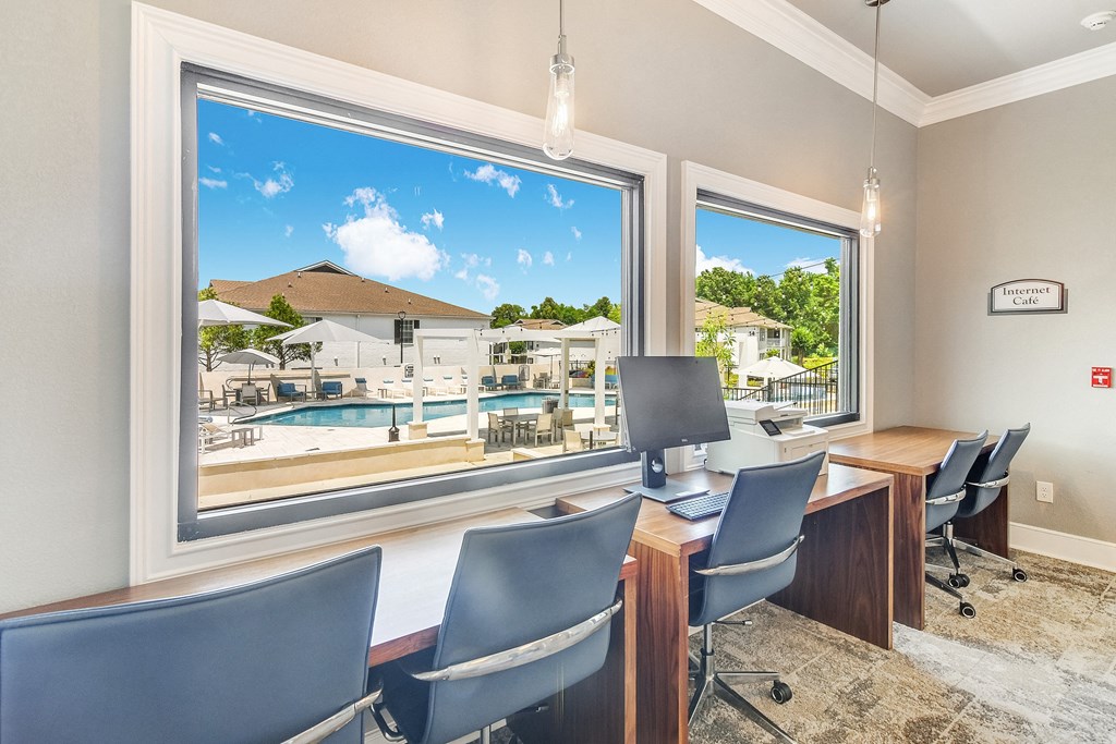 a conference room with a view of a pool and a desk with a computer