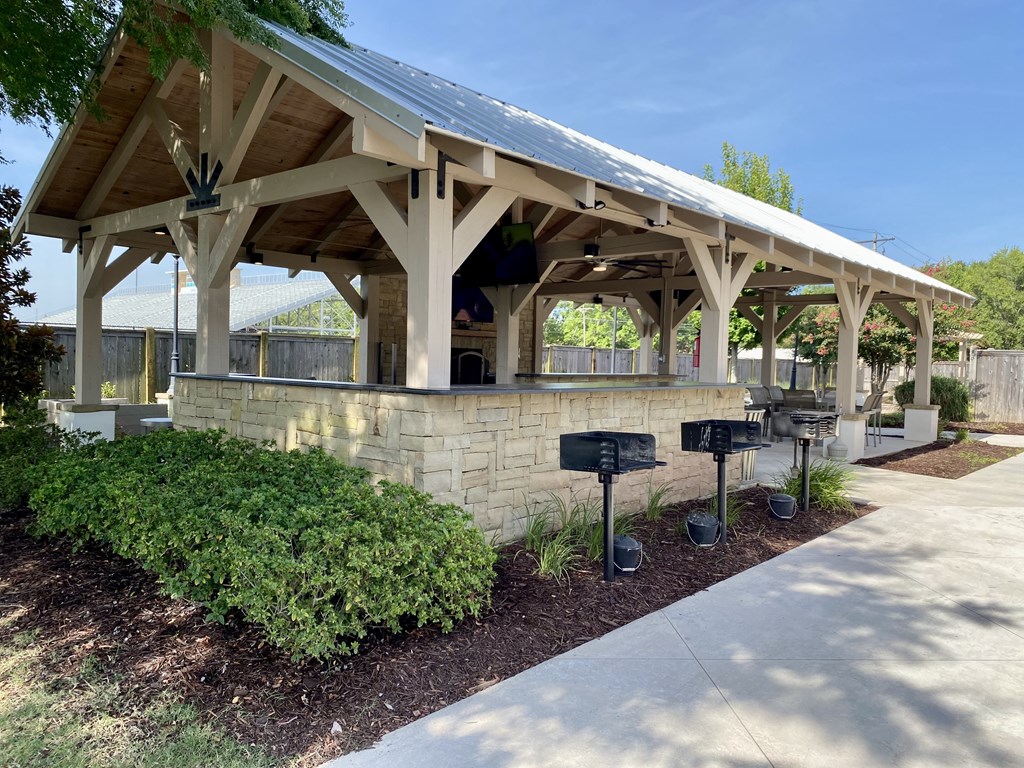 A covered walkway with a stone wall and mailboxes.