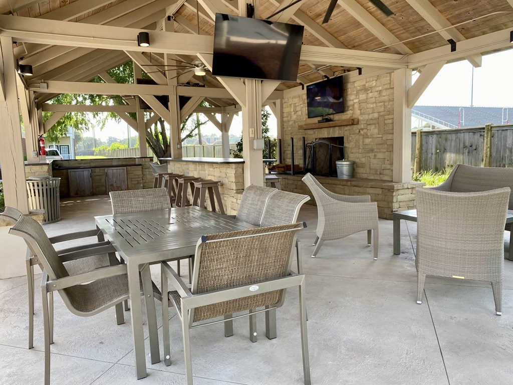 A patio with a table and chairs and a television.