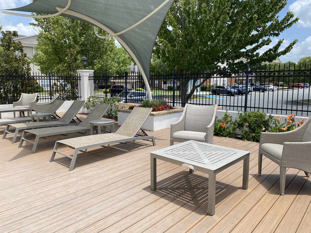 A patio with a table and chairs under a shade sail.