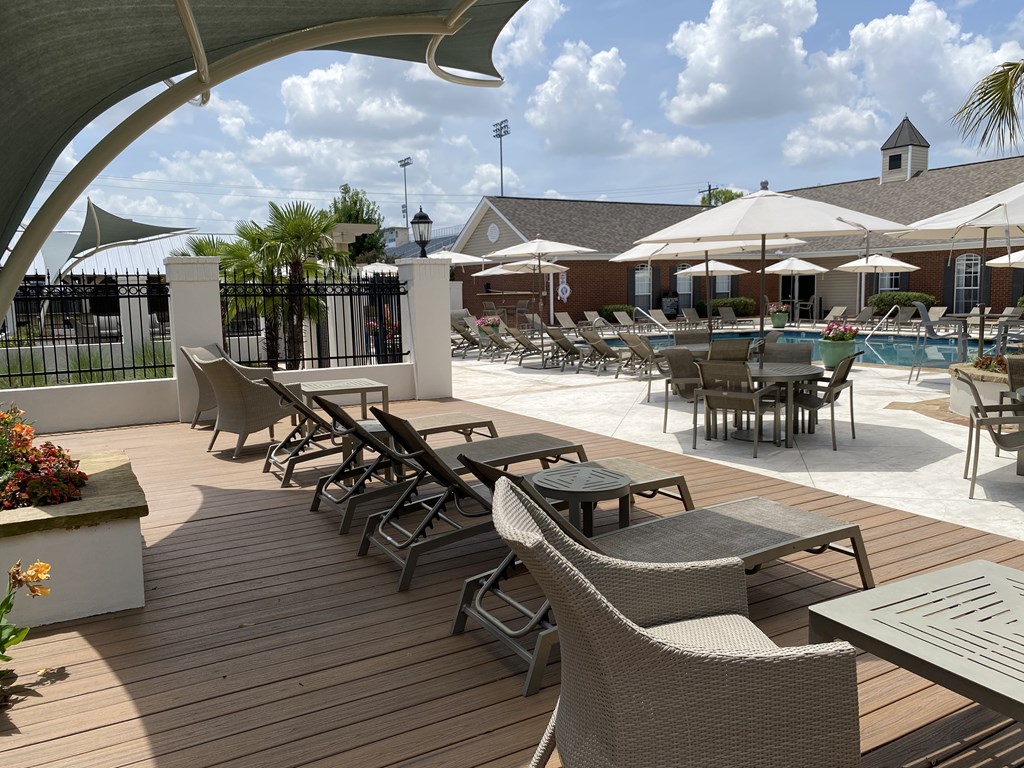 A poolside area with chairs and tables.