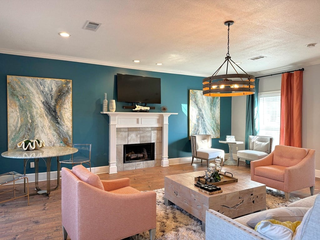 a living room with blue walls and a white fireplace at The Vineyard at Castlewoods Apartment Homes in Brandon, MS