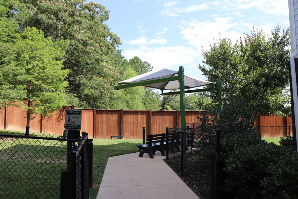 a picnic area in a park with a bench and a canopy at The Met Apartment Homes, Hattiesburg, 39402