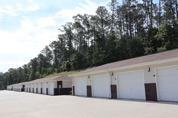 a row of garages with white doors and a roof at The Met Apartment Homes, Mississippi 39402