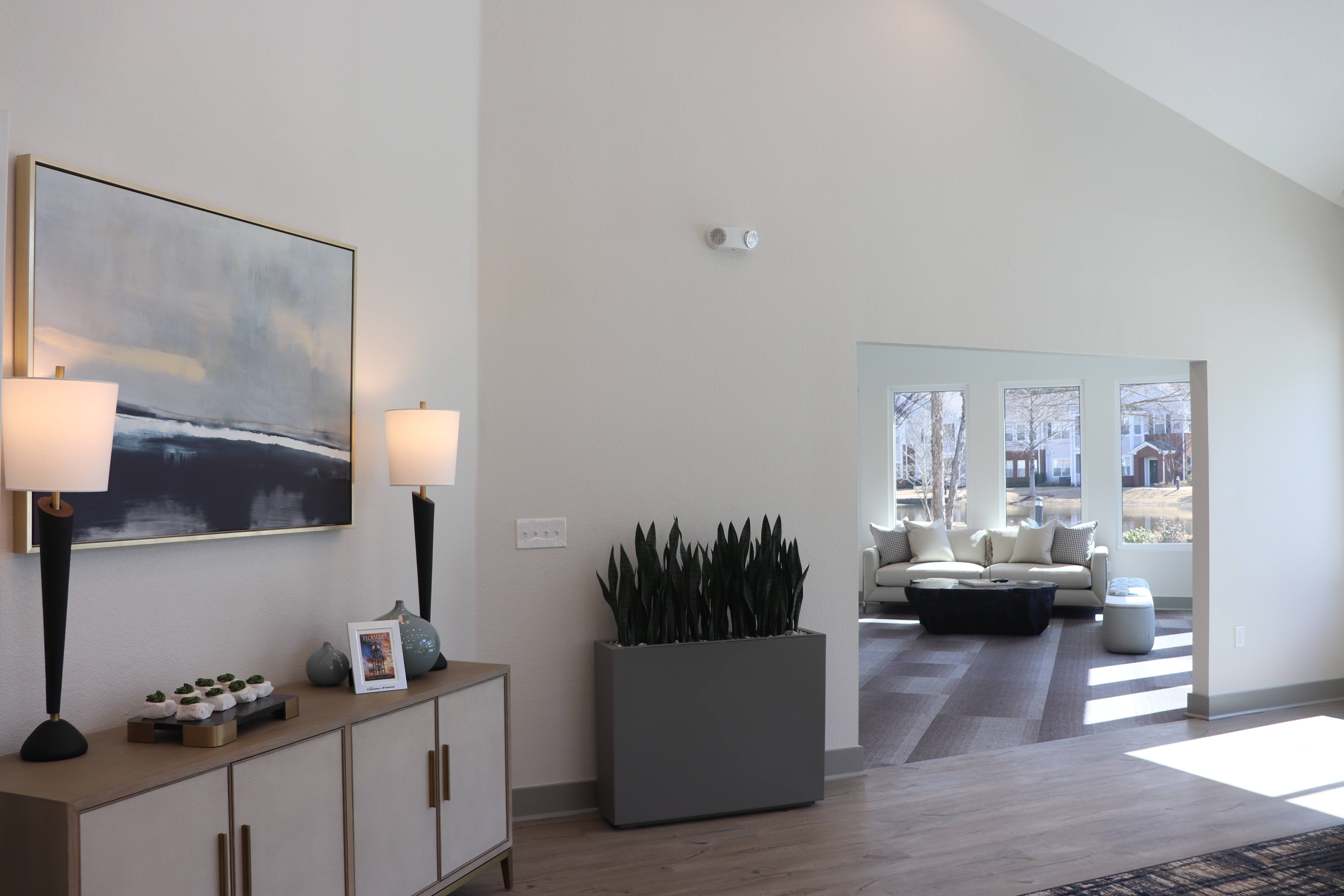 A living room with a painting on the wall and a couch in the background.