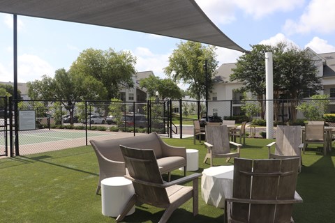 A white canopy is over a set of chairs and tables.