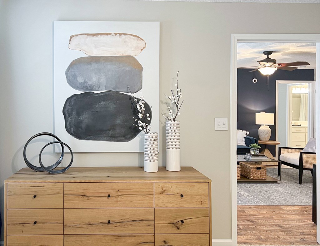 a living room with a painting on the wall and a wooden dresser at Reserve at Park Place Apartments, Hattiesburg, 39402