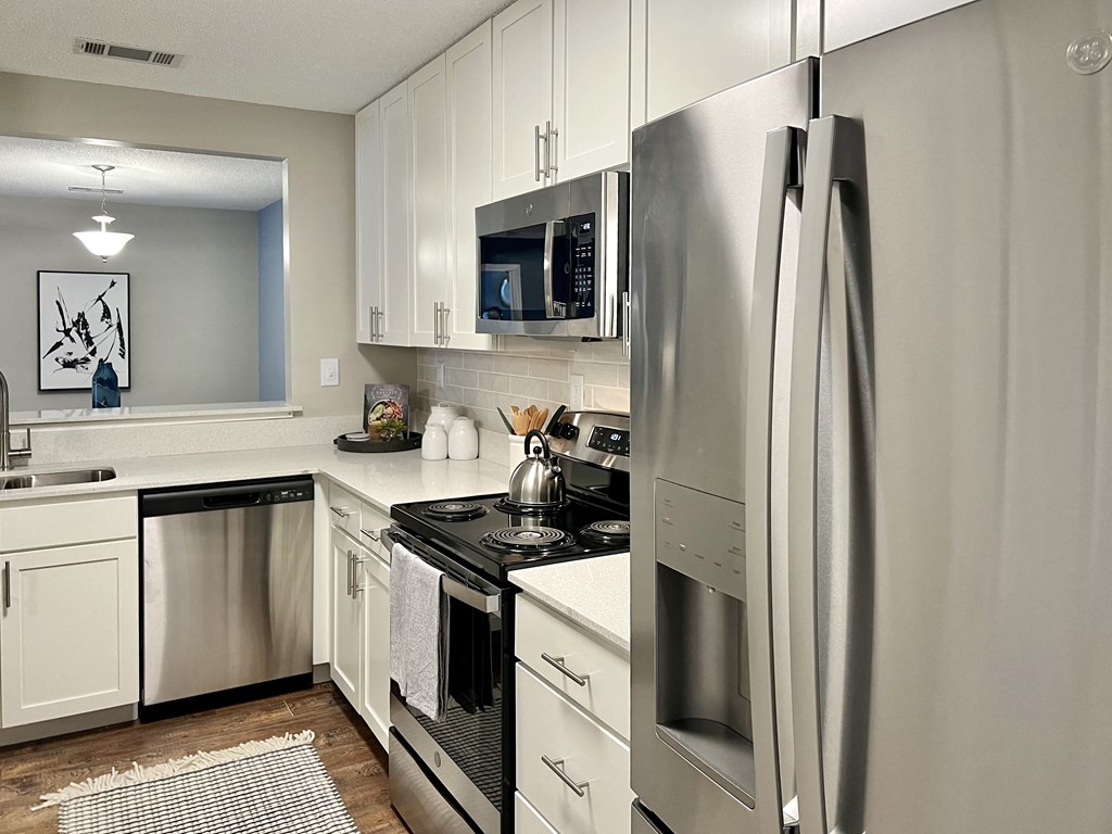 a kitchen with stainless steel appliances and white cabinets at Reserve at Park Place Apartments, Hattiesburg