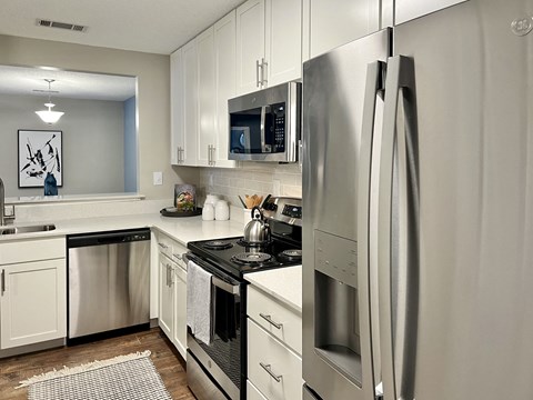 a kitchen with stainless steel appliances and white cabinets at Reserve at Park Place Apartments, Hattiesburg