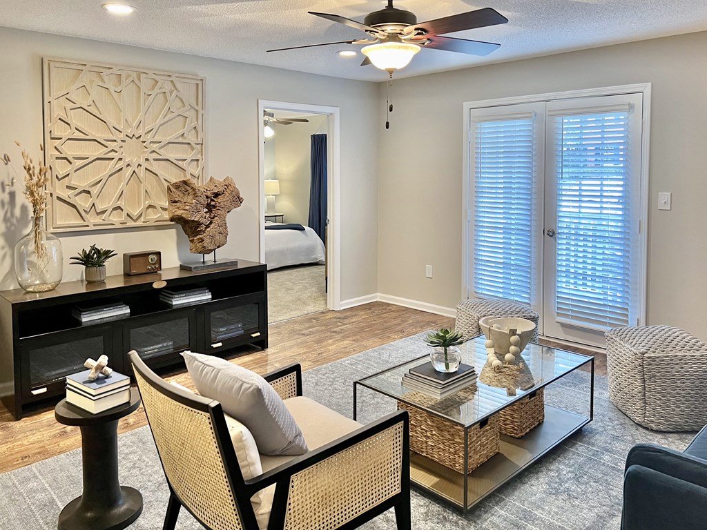 an empty living room with a ceiling fan and a glass table at Reserve at Park Place Apartments, Hattiesburg, Mississippi