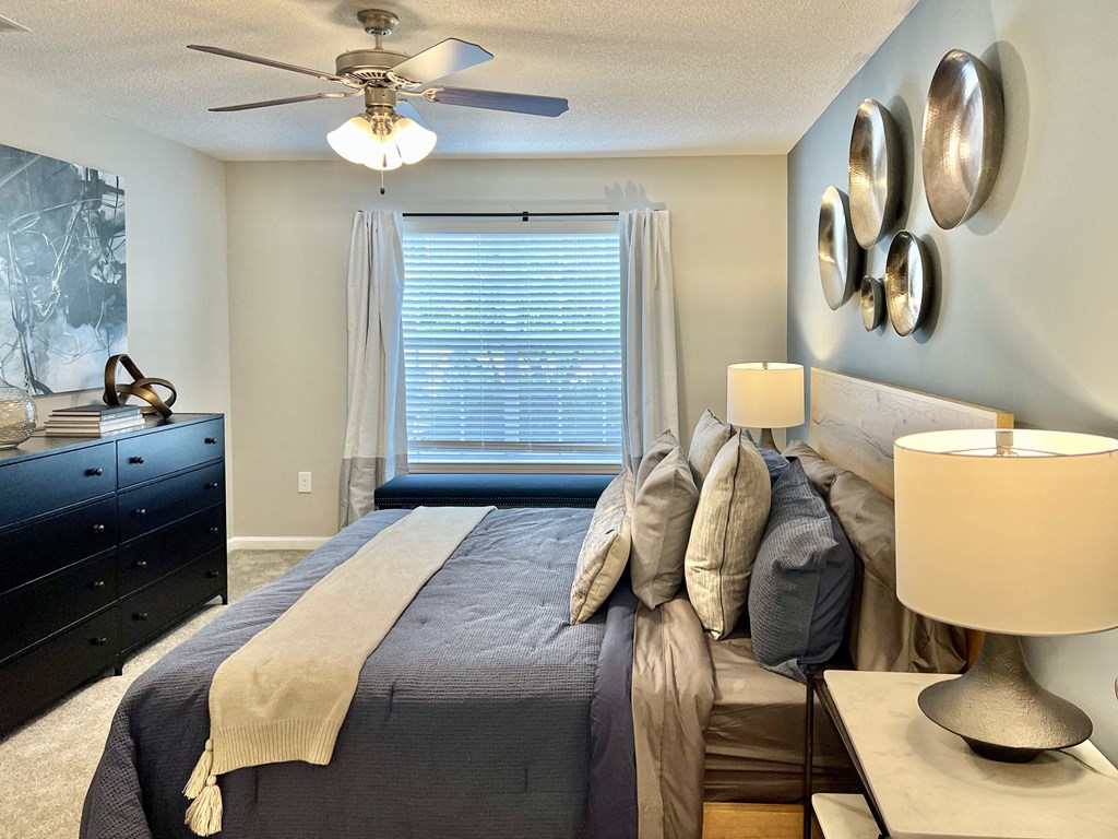 a bedroom with a large bed and a ceiling fan at Reserve at Park Place Apartments, Hattiesburg, MS, 39402