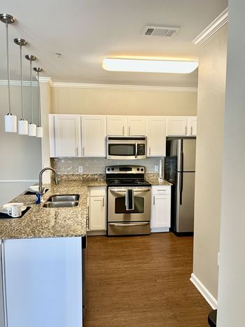 A kitchen with white cabinets and stainless steel appliances at Cumberland Place Apartment Homes, Tyler, TX