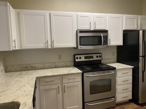 A kitchen with white cabinets and a black fridge at Summit of Shreveport Apartments, Shreveport, LA, 71105