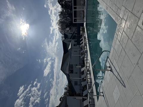 The sun is shining brightly in the sky above a building.